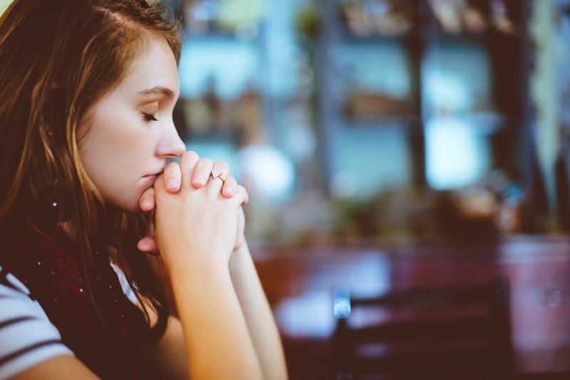 cute small girl praying in the church and Jesus giving blessing