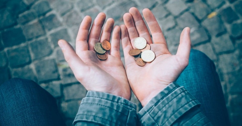 man holding coins, give thanks to the lord