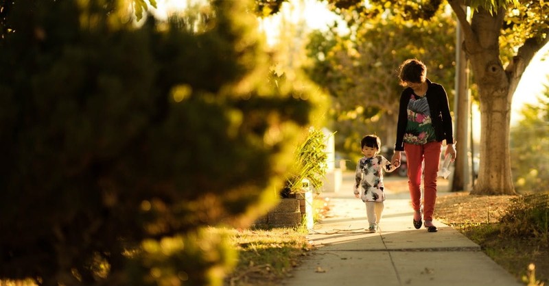 mom walking with son down sidewalk