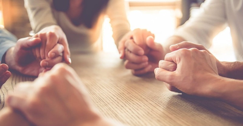 group holding hands praying