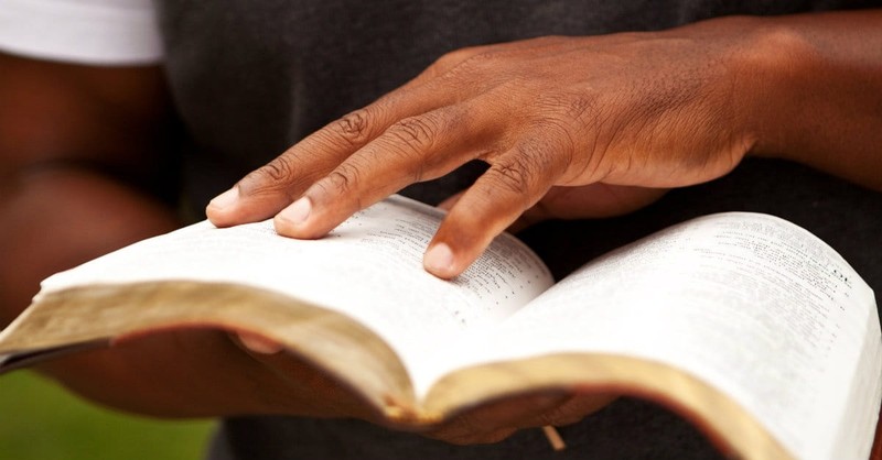 Man holding open a Bible