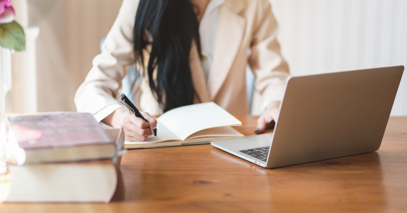 woman writing at her desk