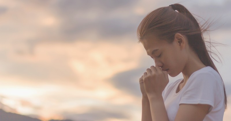 asian woman praying outside