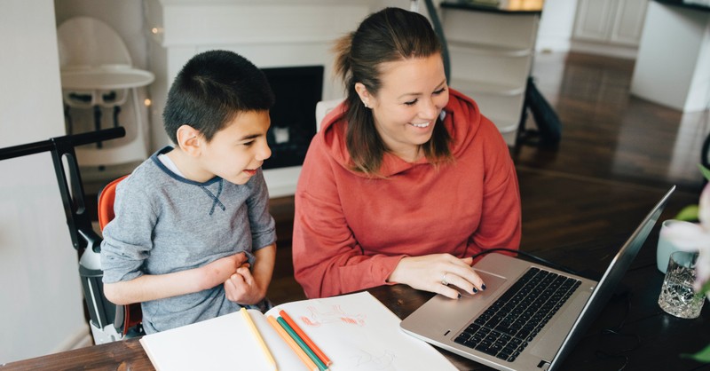 mom looking at computer with special needs son