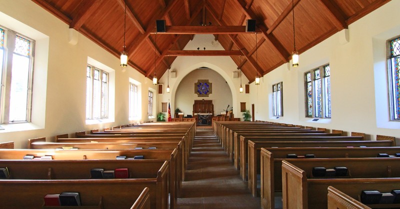 empty church inside sanctuary with wooden pews