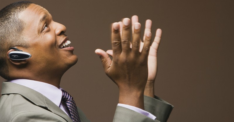 man looking up with hands parted, smiling in worship and praise