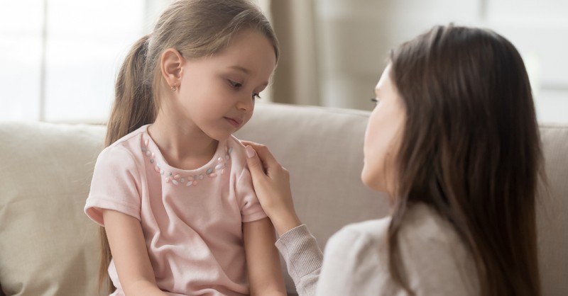 mom talking serious to young daughter