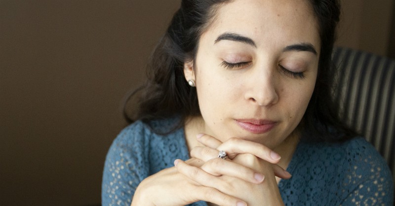 woman praying looking peaceful