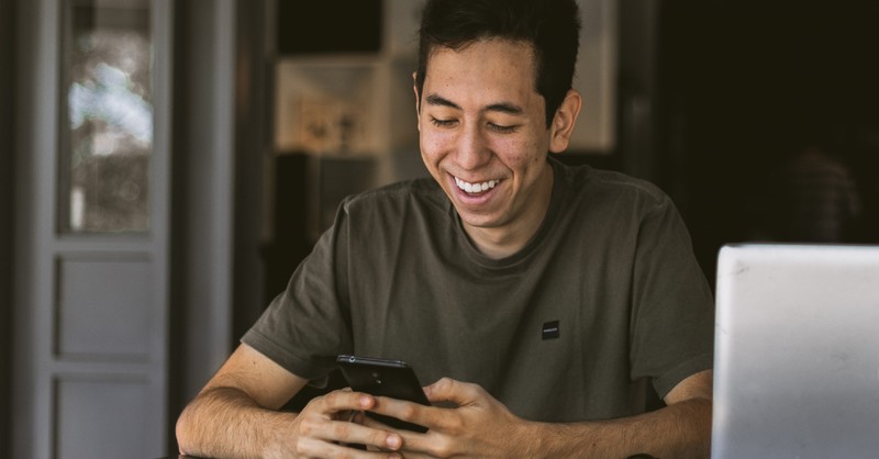 man getting text and smiling