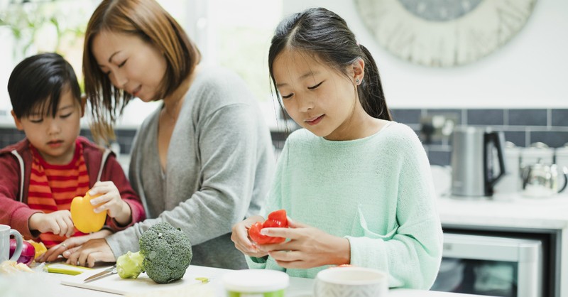 mom cooking healthy dinner in kitchen with kids