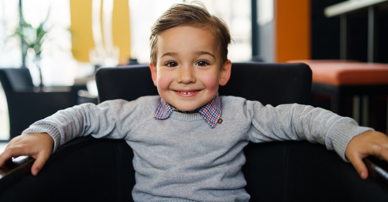 little boy smiling in chair