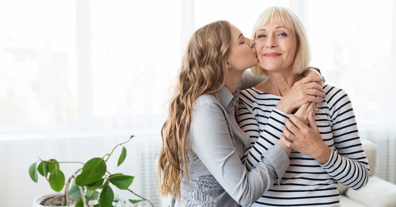 adult child kissing mom on cheek