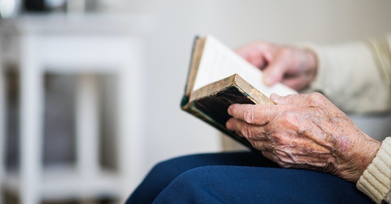 An old person holding a Bible, WWII veteran starts a prayer chain for a spiritual revival