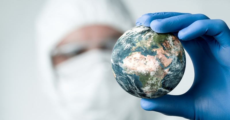 Man in hazard gear holding a globe