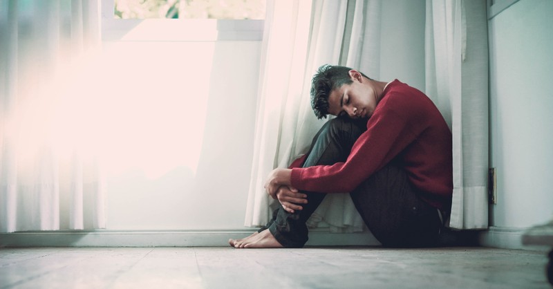 anxious depressed man sitting in a corner
