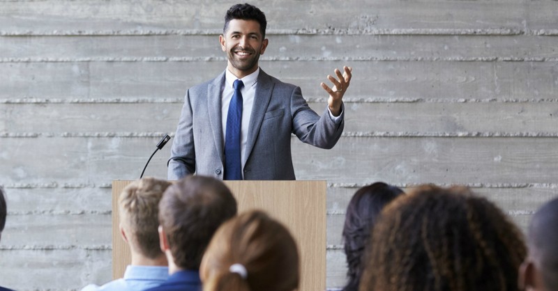 pastor smiling preaching sermon to audience