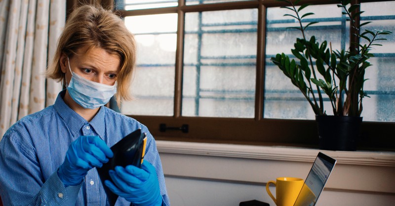 worried woman looking in wallet with face mask on coronavirus, prayers to check heart