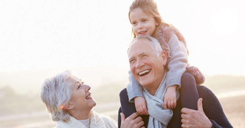 grandparents with grandchild playing outside