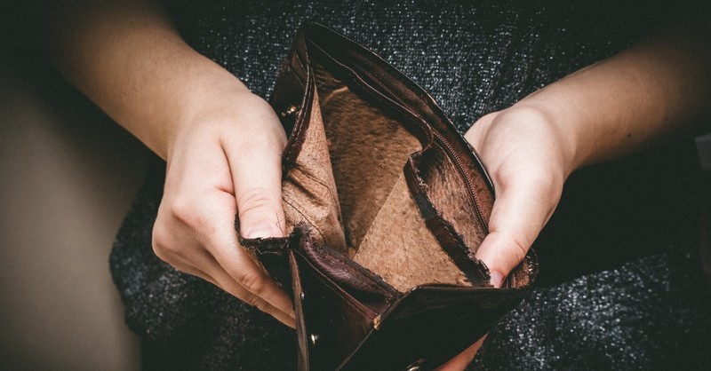 Woman holding open an empty wallet, how to pray for someone