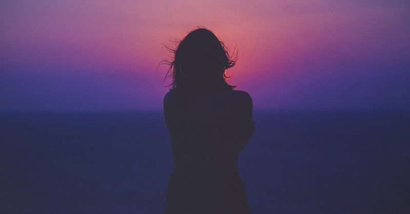 woman silhouette standing in front of ocean sunset sunrise, helen keller quotes about suffering