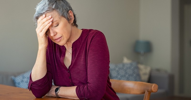 senior woman looking discouraged or tired with eyes closed and head in hand, stop giving out of what you don't have