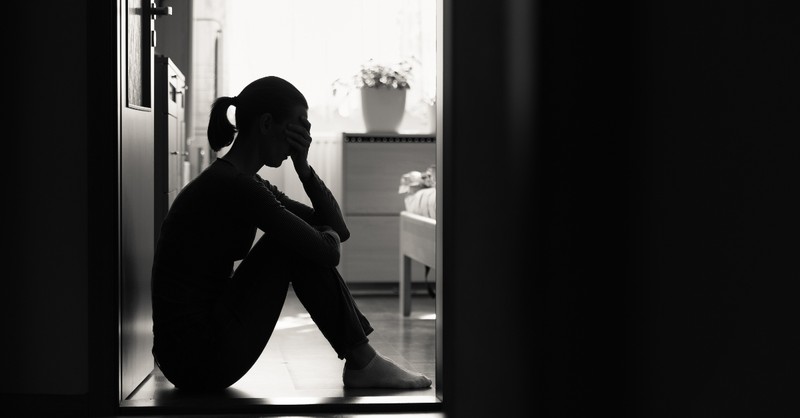 Woman looking distressed sitting in her house