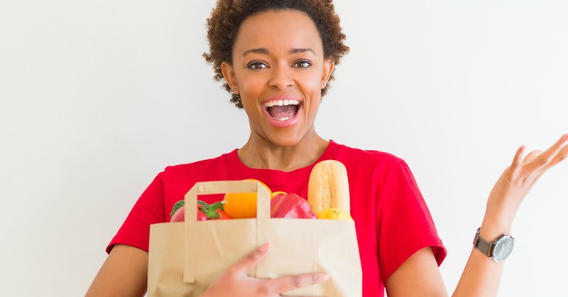 happy woman holding bag of groceries grateful generous giving