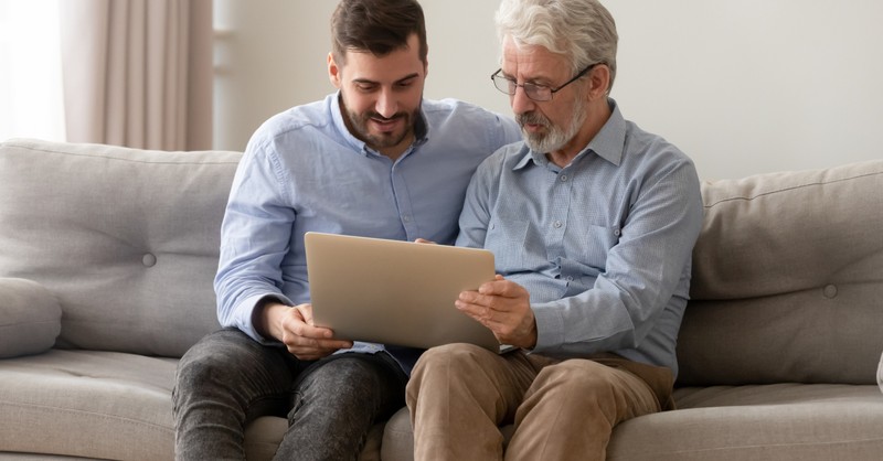 adult son and dad on couch reading laptop, adult children asking for friendship