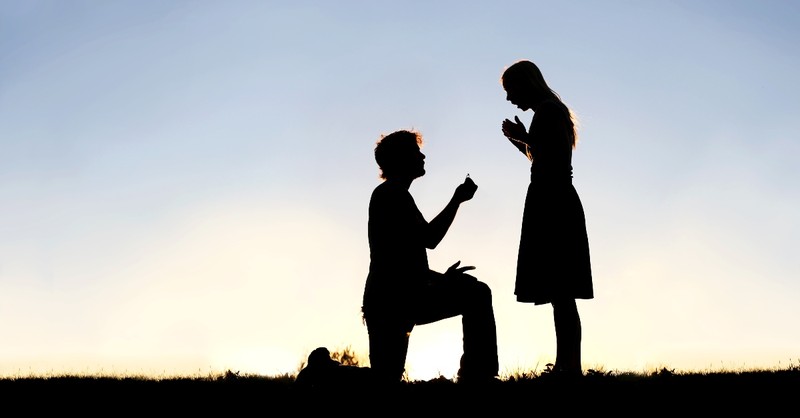 silhouette of man on knee asking woman to marry him, ready to marry