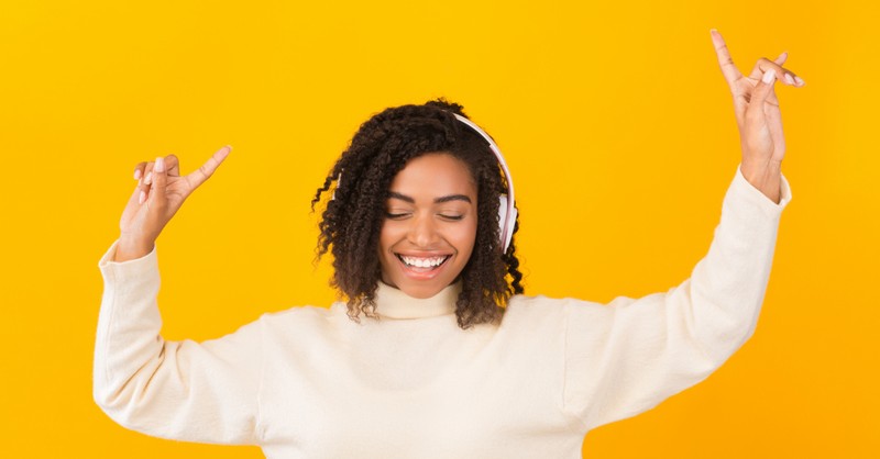 woman with headphones signing to praise music worship pointing up