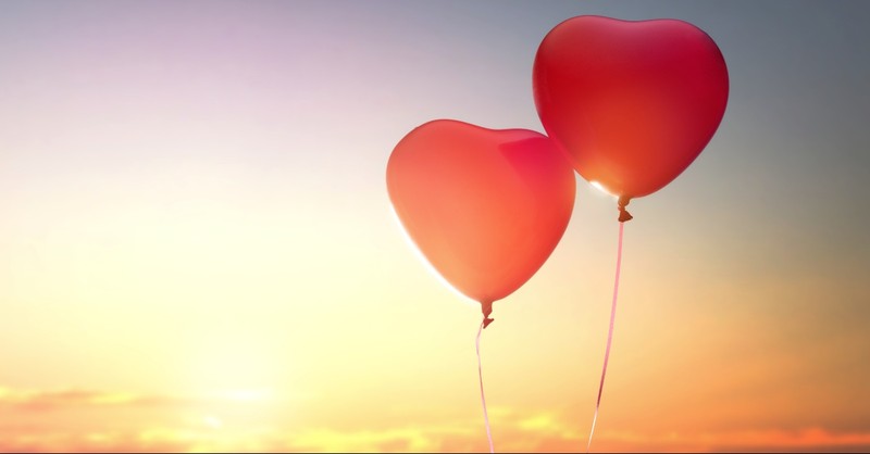 Two heart balloons in the sunset