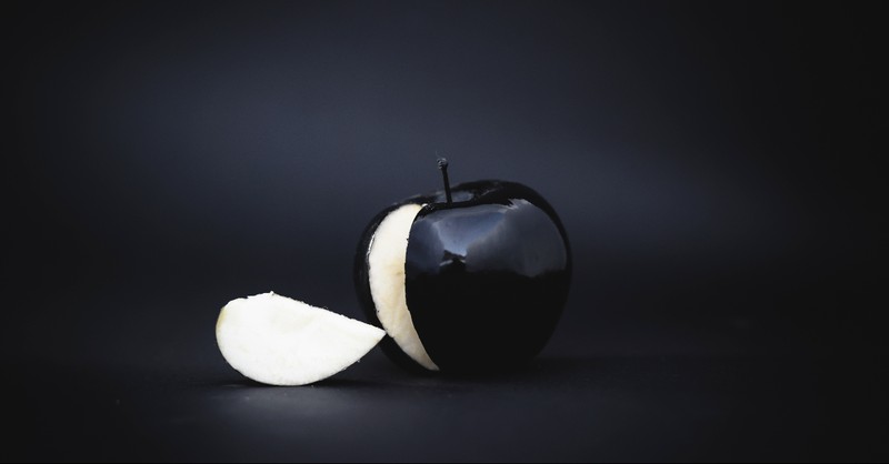 A black apple with a black background