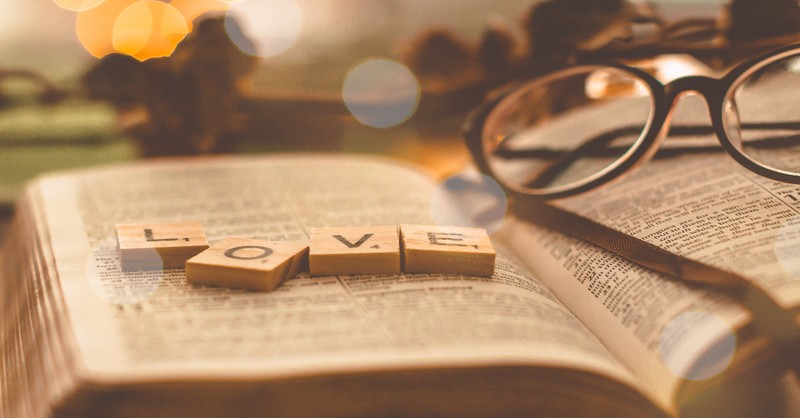 scrabble words love on top of bible next to glasses, inspirational sayings about god's love for humanity