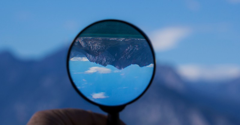 seeing mountain clearly upside down through magnifying glass