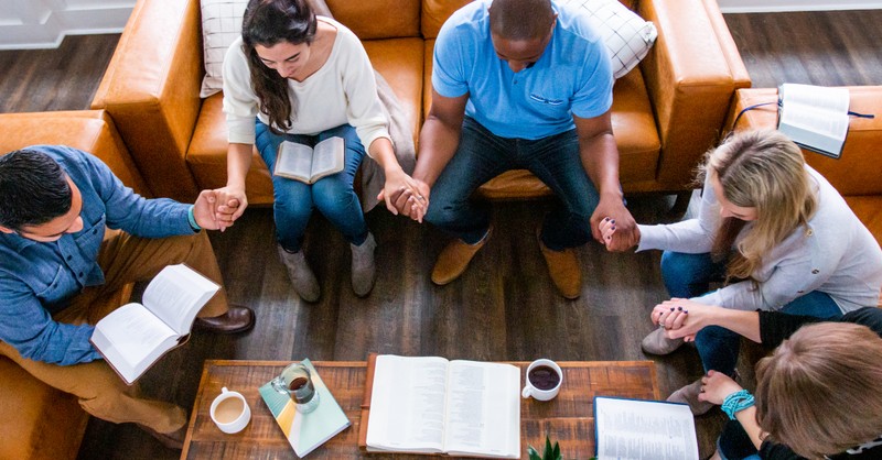 bible study friends holding hands praying for a hedge of protection