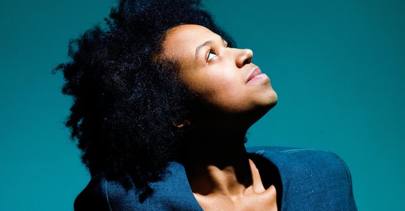 young confident black woman looking up into light