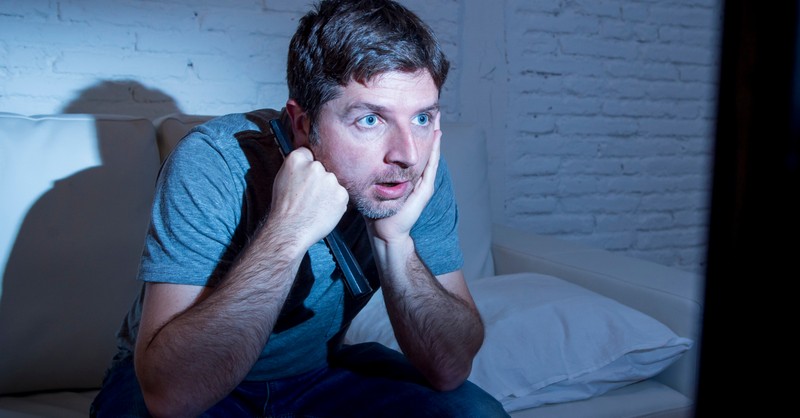 man addicted to television news staring