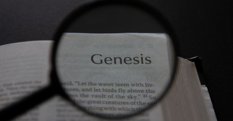 Bíblia aberta ao livro de Gênesis com lupa para significar a maçã do meu olho