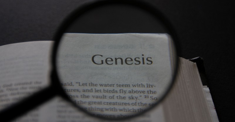 Bible open to book of Genesis with magnifying glass, sodom and gomorrah