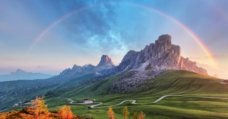 mountain range in beautiful green landscape with rainbow, for every mountain hymns of praise