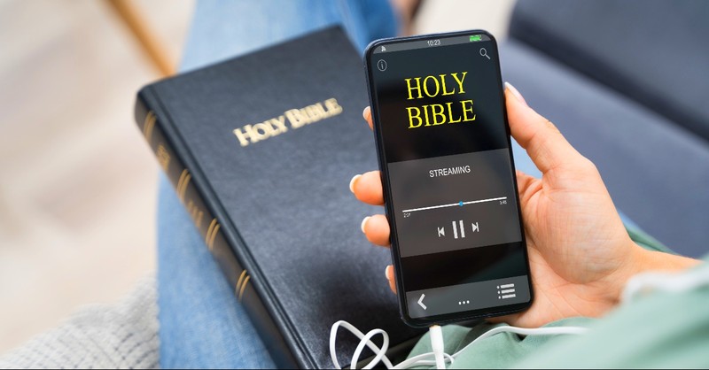 Woman with a Bible and a Bible audio book on her phone