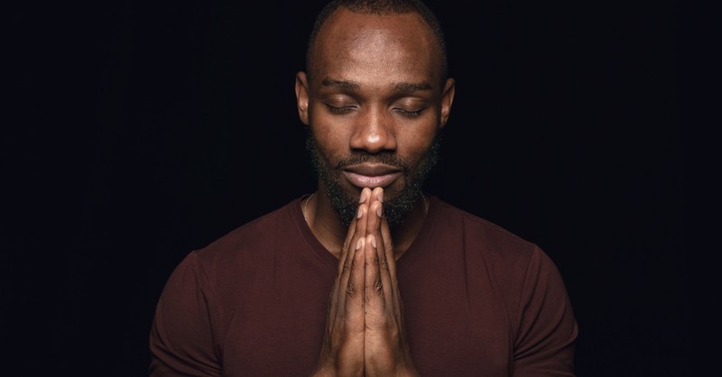 man with eyes closed saying a prayer for abundant life