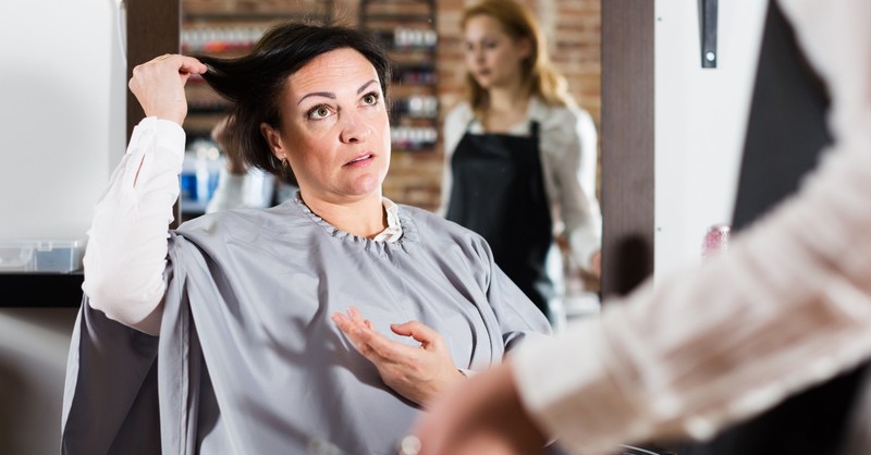 mature woman in salon looking upset about a haircut