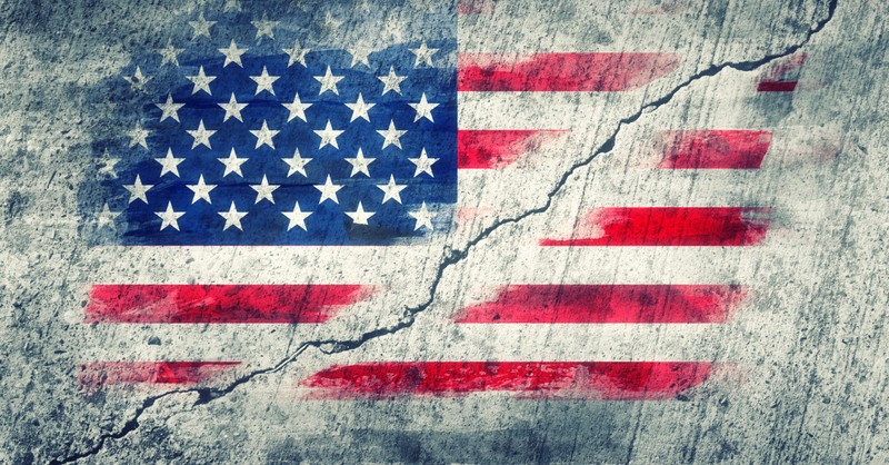 american flag painted on wall that is cracked to signify divisive politics in election season