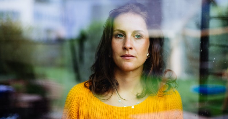 woman contemplating and looking out window, the sin of envy