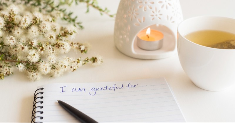 Journal to be grateful today, candle, and tea