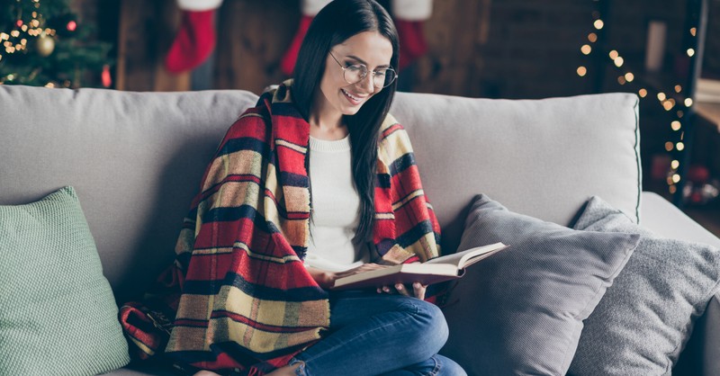 woman with blanket reading by fireplace first Sunday of Advent