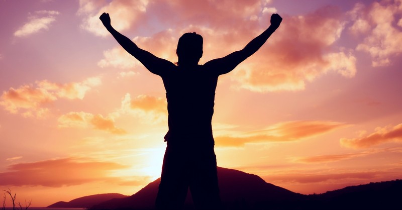 Man with arms up in victory, faith is the victory hymns about heaven