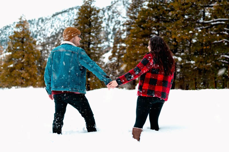 couple walking in snow sharing the gift of time at Christmas