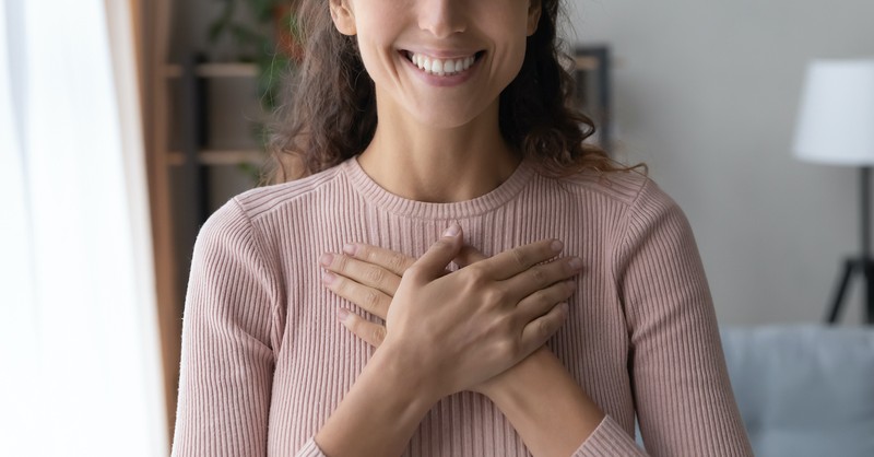 women smiling and crossing hands over heart, out of the heart the mouth speaks